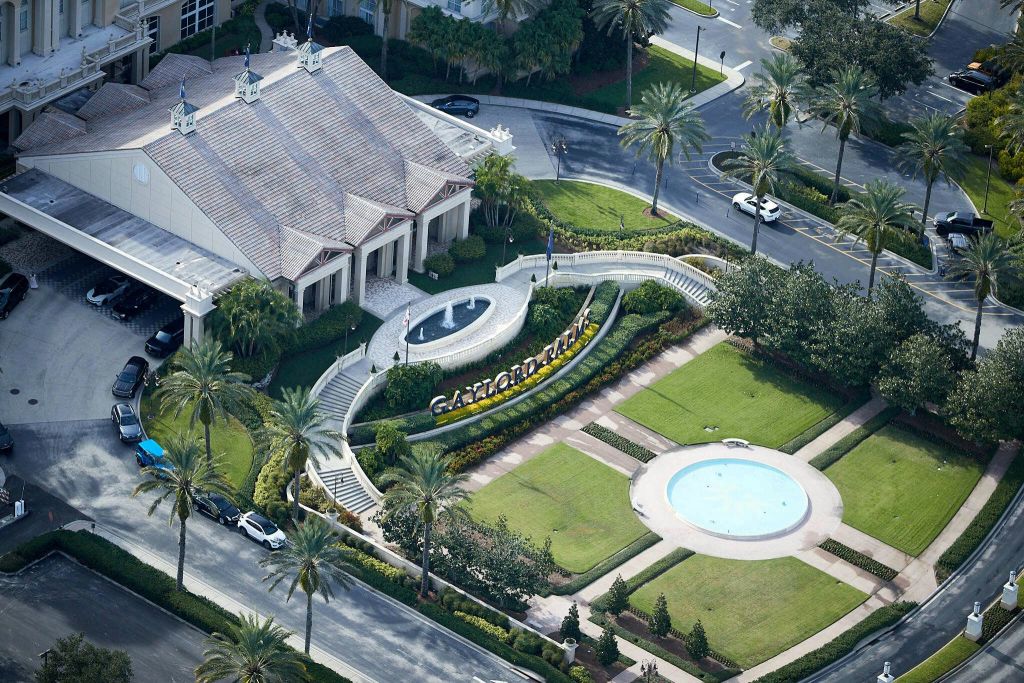 분수, 조경된 정원, 주변 도로와 주차된 차량이 있는 게이로드 팜스 리조트 입구의 공중 전망.