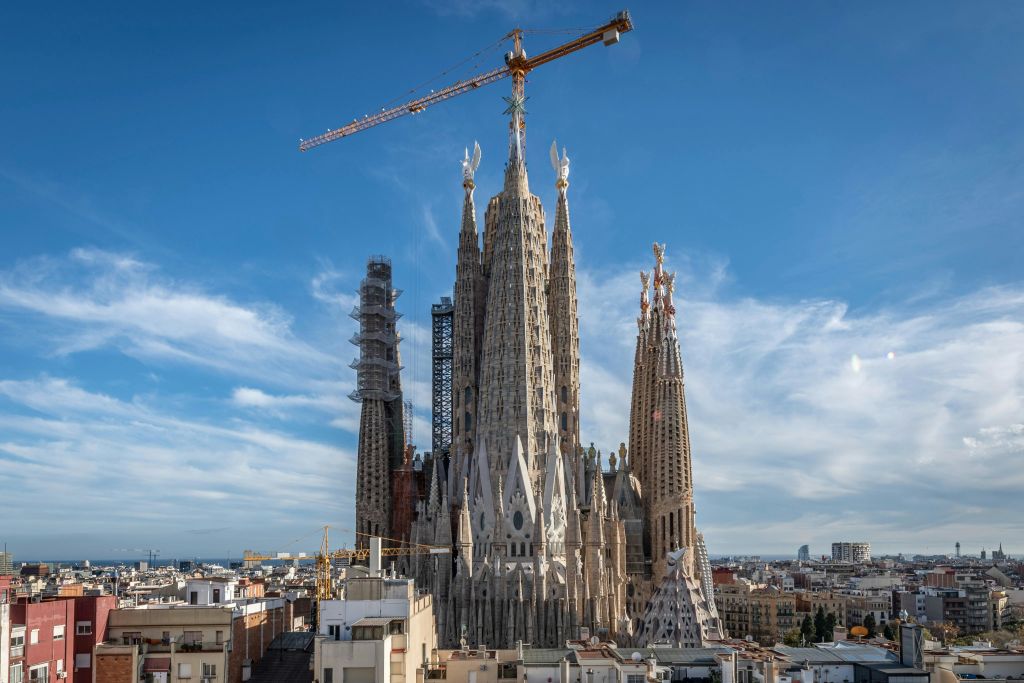 바르셀로나의 사그라다 파밀리아 (Sagrada Familia) 는 맑고 푸른 하늘에 크레인과 비계로 공사 중입니다.