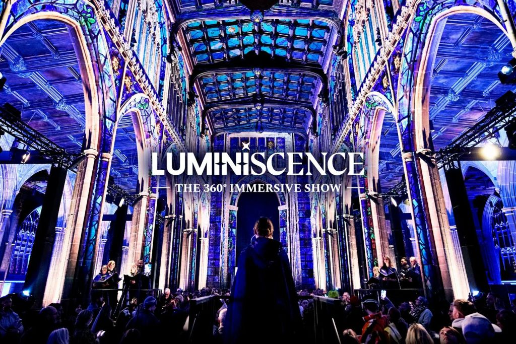 'Luminescence - The 360° Immersive Show' 라는 문구가 겹쳐진 다채로운 대성당 내부가 사람들로 둘러싸여 있습니다.