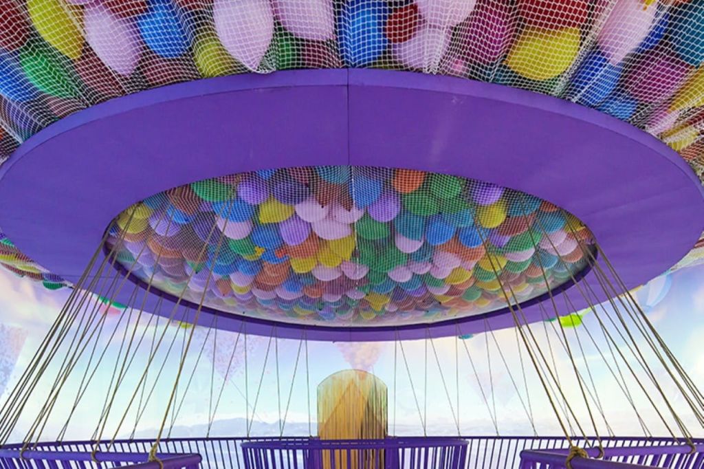 보라색 구조물 내부에 풍선이 가득한 화려한 그물형 천장으로, 측면을 통해 아름다운 전망을 감상할 수 있습니다.
