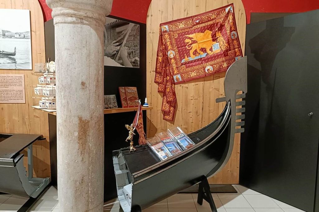 베네치아를 테마로 한 책과 나무 벽에 태피스트리를 배경으로 한 곤돌라 복제품이 실내에 전시되어 있습니다.