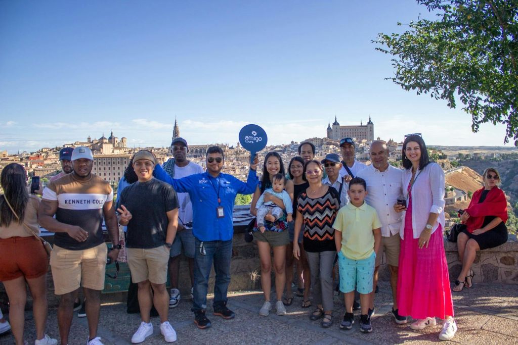 유서 깊은 건물의 경치와 나무를 배경으로 야외에서 사진을 찍으며 포즈를 취하고 있는 사람들입니다.