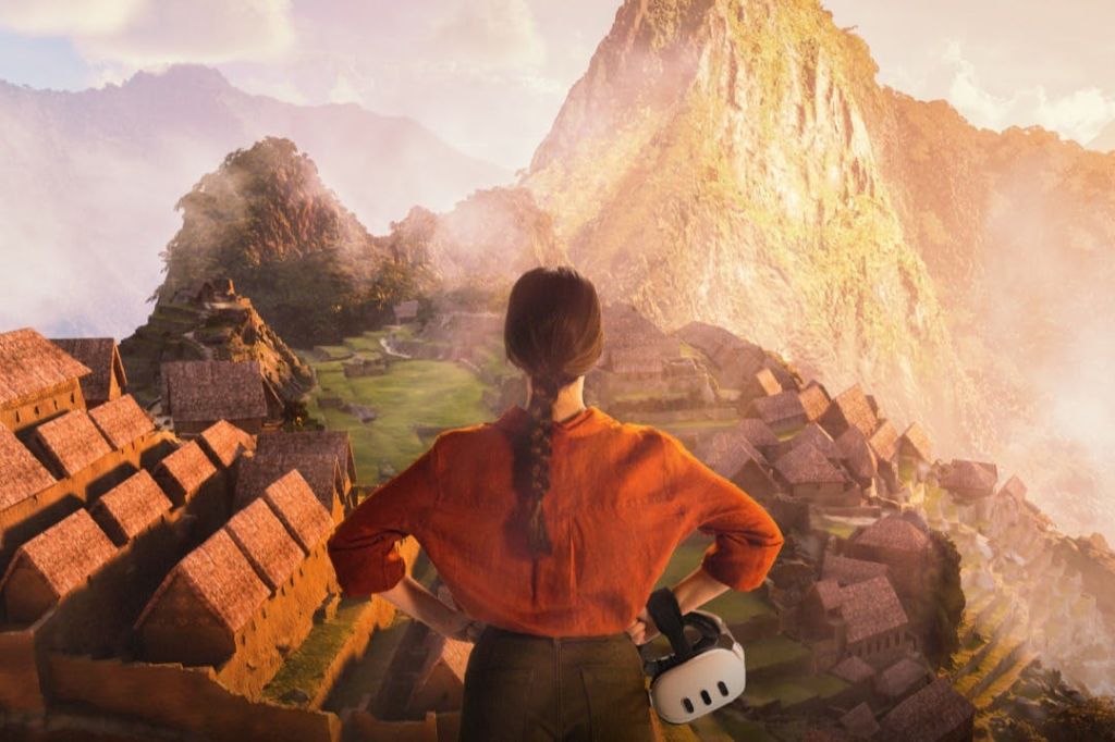 땋은 포니테일이 달린 주황색 셔츠를 입은 한 사람이 해돋이 무렵 마추픽추의 고대 건축물이 내려다보이는 곳에 서서 VR 헤드셋을 들고 있습니다.