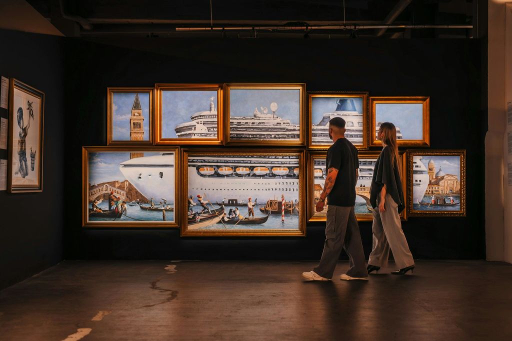 한 커플이 뱅크시의 그림에 감탄합니다.