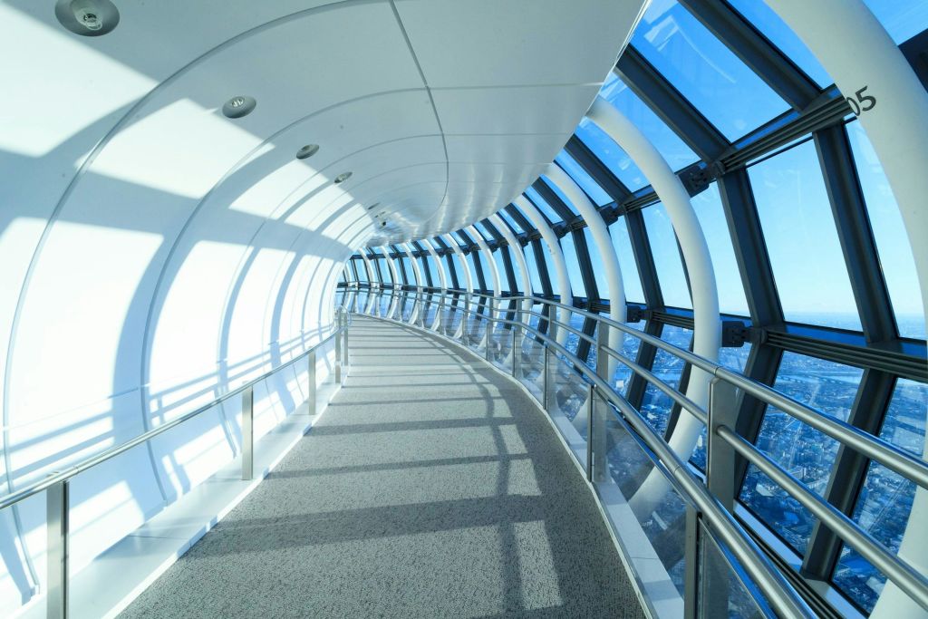 금속 난간이 있는 유리로 둘러싸인 곡선형 통로는 커다란 창문을 통해 한쪽면의 파노라마 전망을 제공합니다.