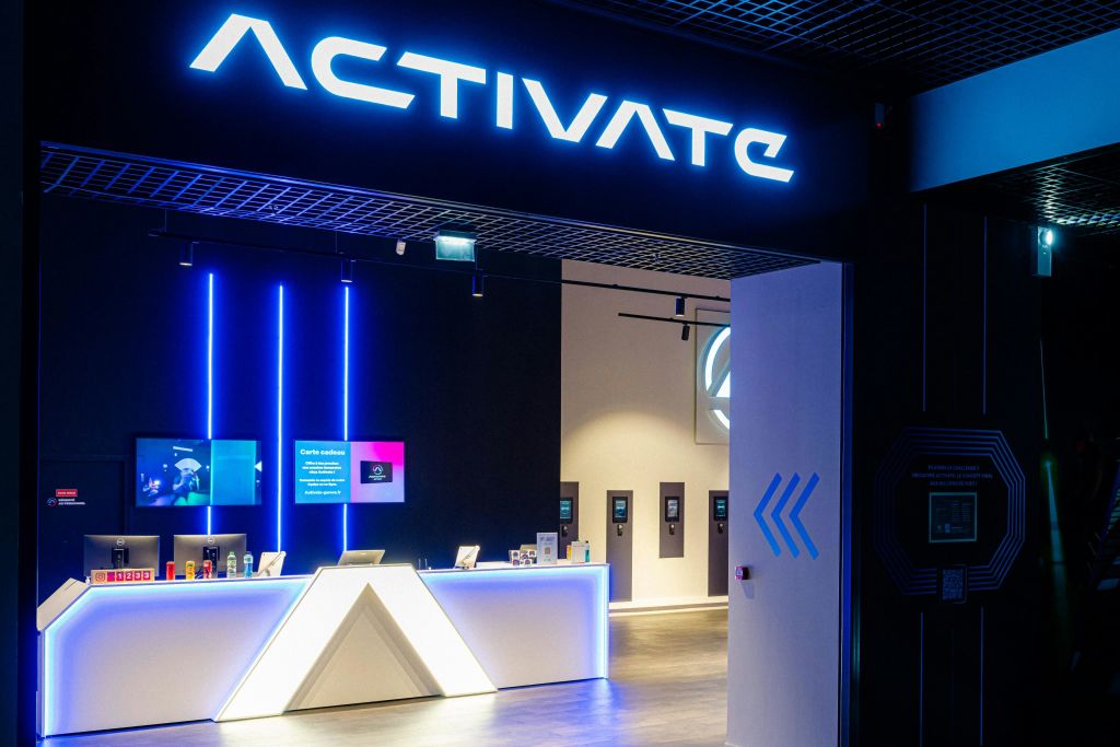 빛나는 "Activate" 표지판 아래에 조명이 있는 현대적인 리셉션 공간입니다.