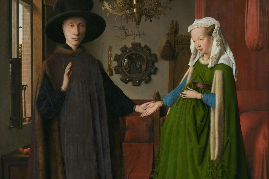 어두운 가운과 모자를 쓴 사람이 다른 사람의 손을 잡고 창문과 화려한 장식이 보이는 내부에 서 있습니다.