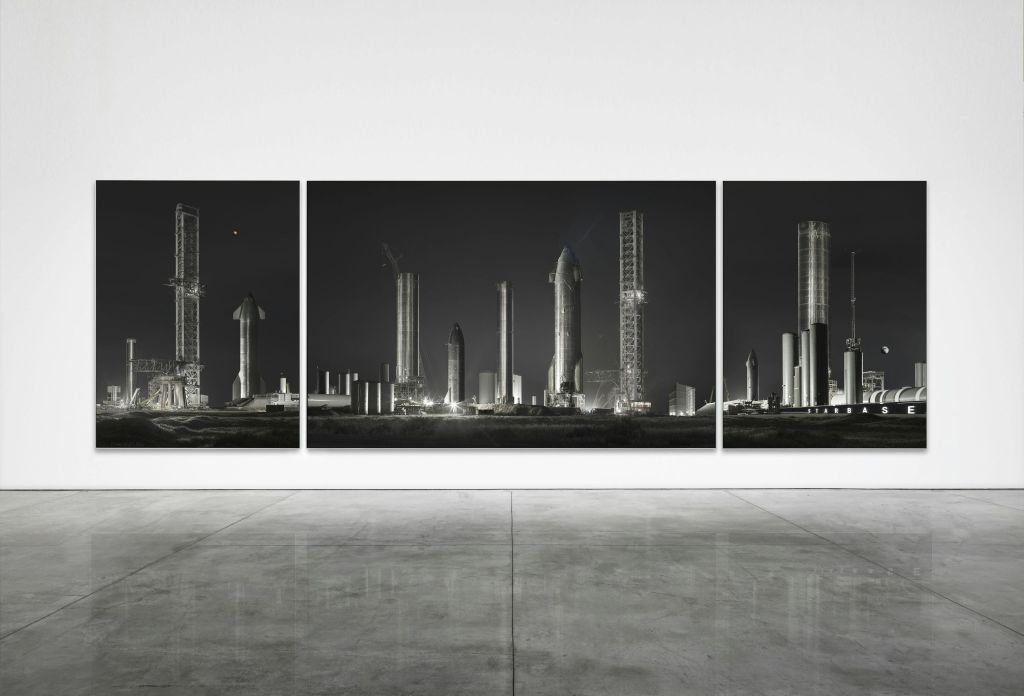 Triptych 이미지는 흰색 벽에 표시된 어두운 하늘에 대한 여러 로켓 구조와 발사 타워를 보여줍니다.