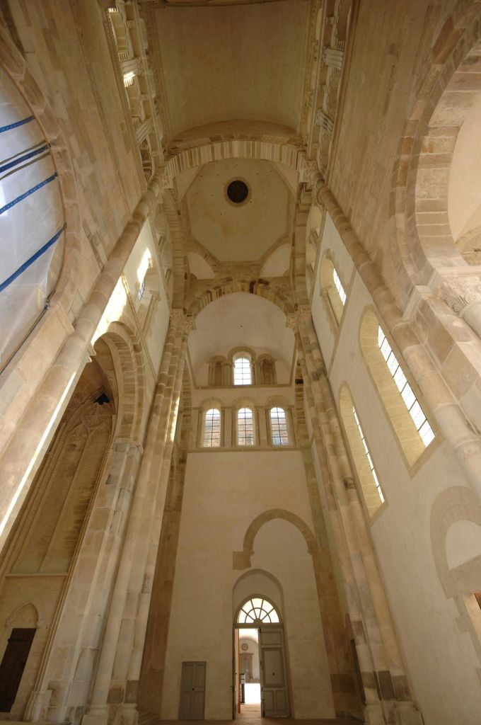 아치형 창문과 석조 기둥이 있는 높고 유서 깊은 건물의 내부로, 지상에서 올려다볼 수 있습니다.