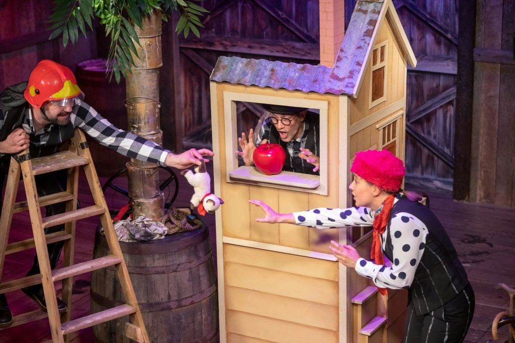 한 명은 사다리에, 다른 한 명은 사과가 달린 창문에, 다른 한 명은 빨간 가발을 쓰고 손을 뻗는 장난기 넘치는 장면을 연출합니다.