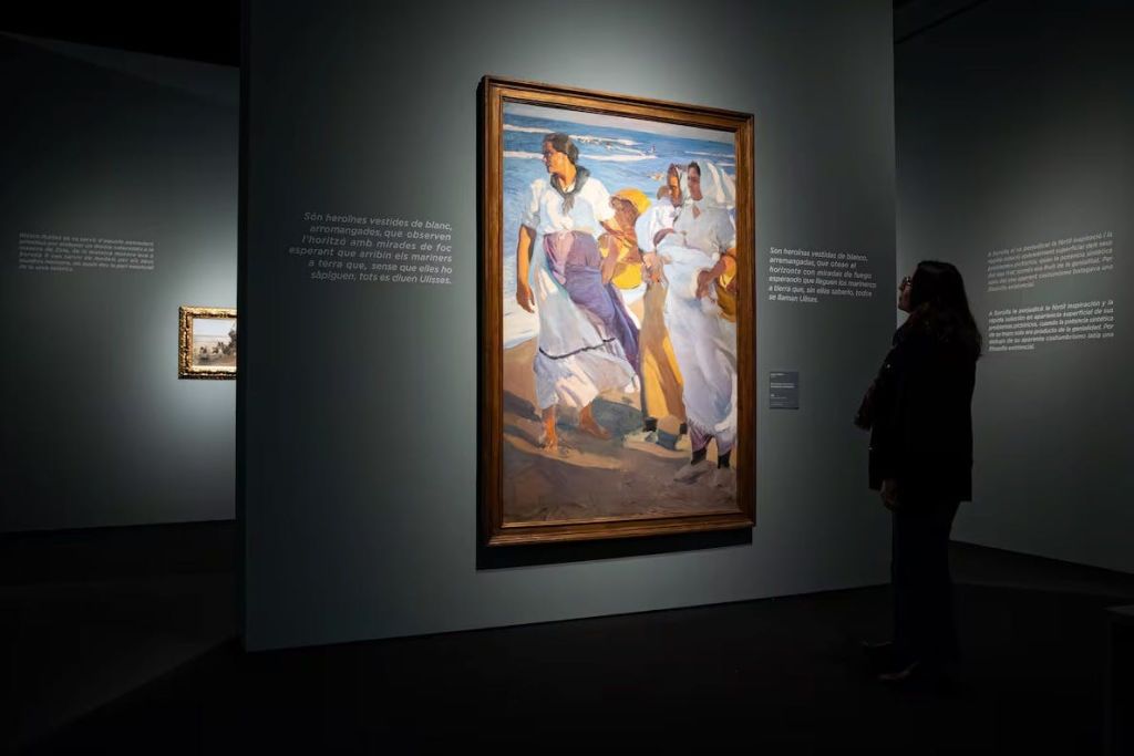 박물관에 전시된 그림으로, 해변에 서 있는 한 여성이 조명이 어두운 방에 서 있는 모습을 담고 있습니다.