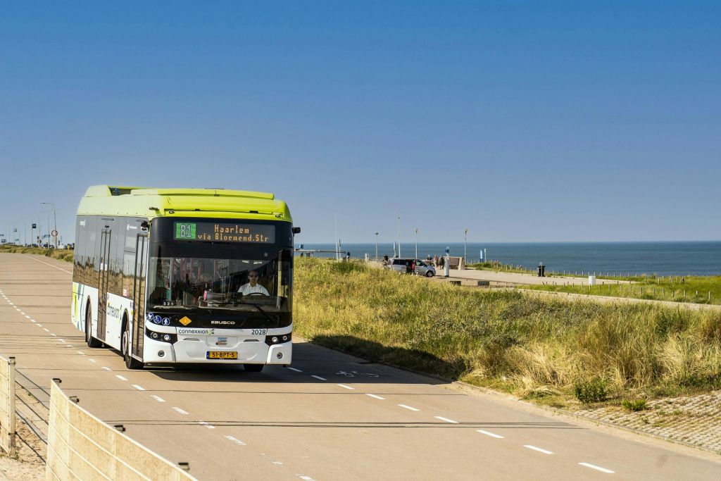 할렘으로 가는 81번 대중 버스는 잔디가 우거진 모래 언덕과 바다를 배경으로 해안 도로를 달립니다.