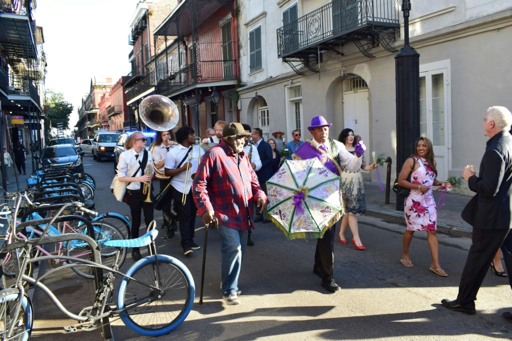 화려한 우산을 든 남자, 음악가, 매력적인 도심 거리를 걷는 사람들과 함께하는 축제 거리 퍼레이드.