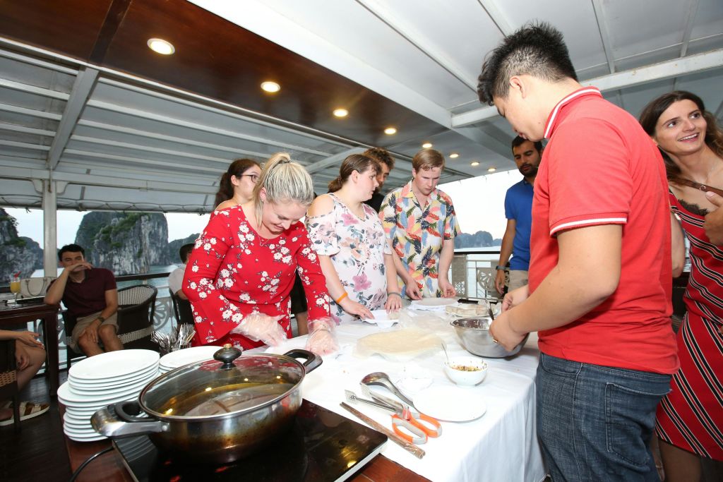 사람들은 캐노피 아래 테이블에 모여 다양한 재료와 식기를 이용한 요리 활동을 했습니다.