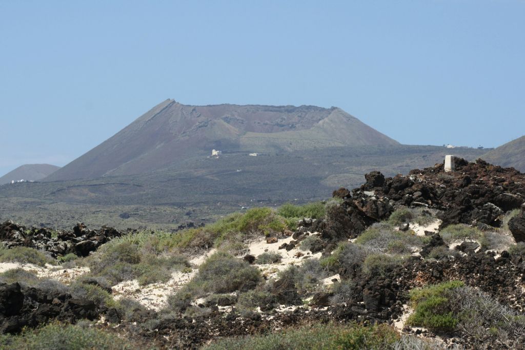 맑고 푸른 하늘 아래 평평한 정상과 마른 초목이 있는 산의 먼 풍경.