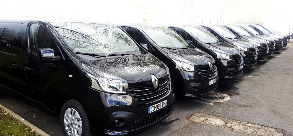 흐린 날에는 검은색 "파리 셔틀" 밴 몇 대가 연달아 주차되어 있습니다.