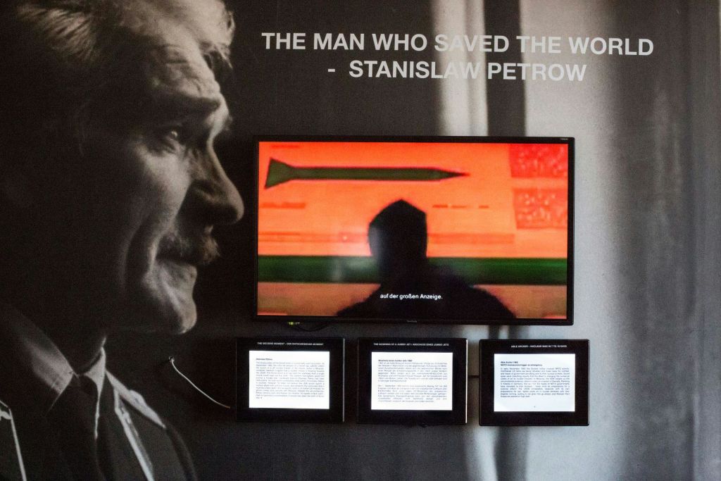 스타니스와프 페트로우의 초상화와 미사일을 보여주는 화면, 그 아래 세 개의 텍스트 패널이 있는 디스플레이.