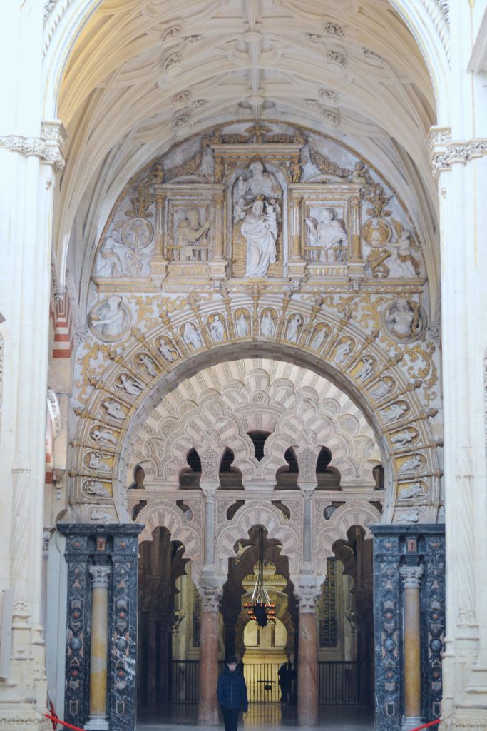 유서 깊은 건물에 정교한 조각과 대리석 기둥이 있는 화려한 아치형 입구가 있습니다.