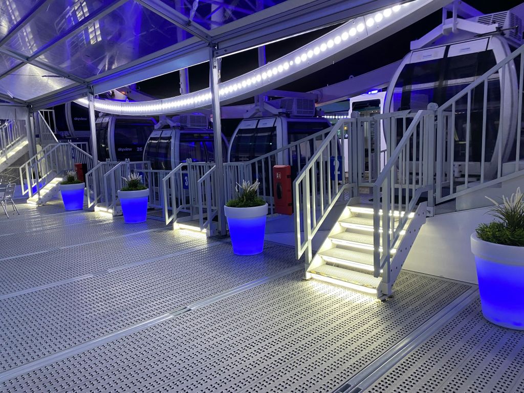 조명이 켜진 계단을 지나면 유리로 둘러싸인 관찰 휠이 나옵니다. 통로를 따라 푸른 빛의 화분이 놓여 있습니다.