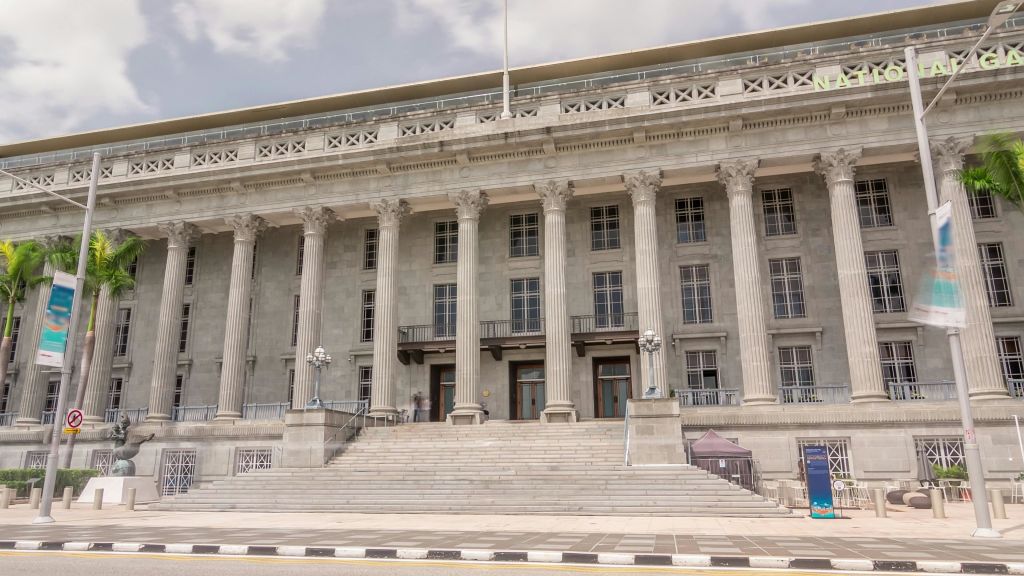 높은 기둥과 넓은 계단, 여러 개의 출입구가 흐린 하늘과 맞닿아 있는 커다란 신고전주의 건물입니다.