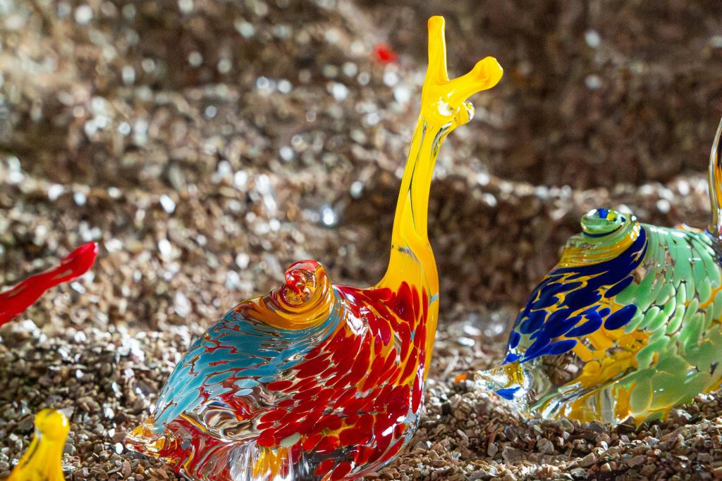 노란색 안테나와 붉은색, 파란색, 주황색 몸체가 질감 표면에 있는 달팽이의 화려한 유리 조각.