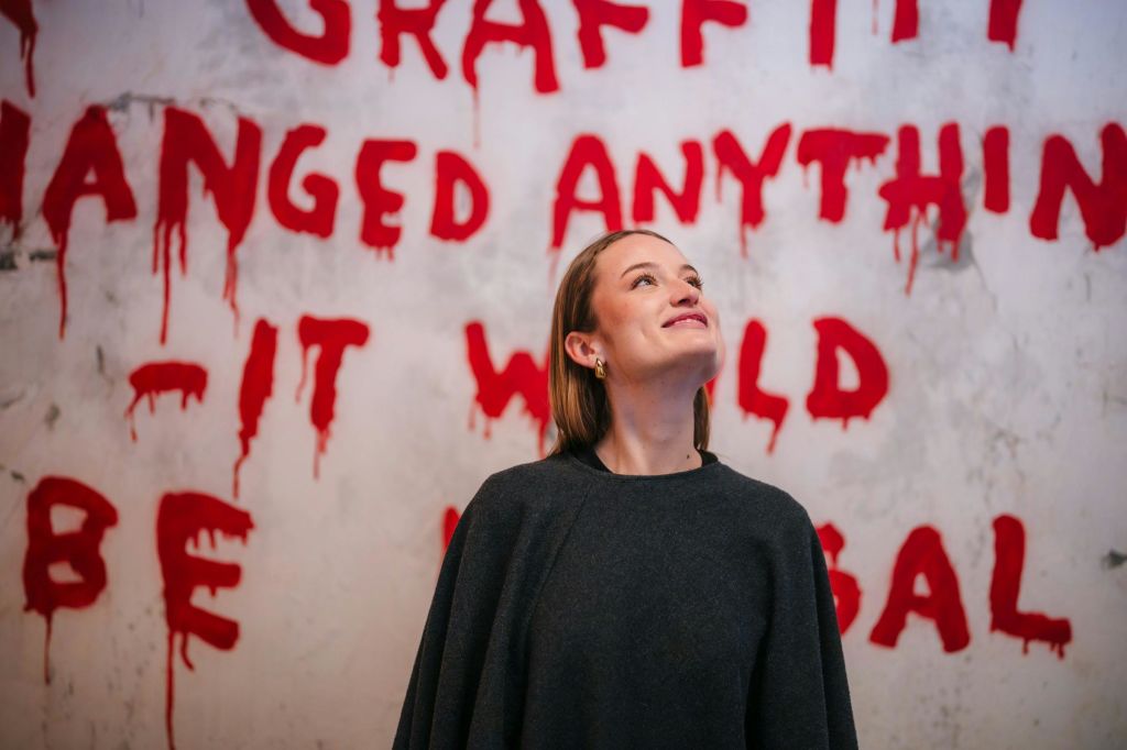 한 소녀가 웃으며 전시실 중 하나를 감상하고 있습니다.