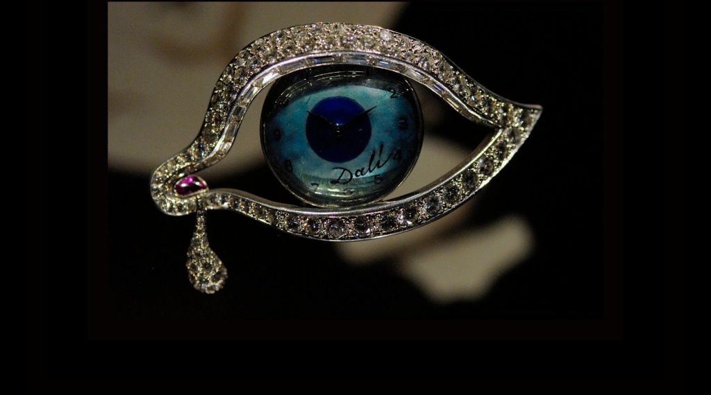 중앙에 시계가 있고 눈물 모양의 펜던트가 있는 다이아몬드 장식의 눈 모양 브로치. 시계면에는 '달리' 라는 이름이 새겨져 있습니다.