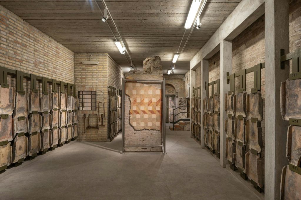 벽돌로 장식된 창고에는 수많은 포장된 유물과 밝은 천장 조명 아래 고대 모자이크가 전시되어 있습니다.