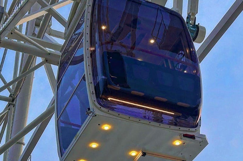 대관람차에 달린 곤돌라에 반사되는 색조 창문과 빛이 들어오는 불빛이 맑은 하늘을 비춥니다.