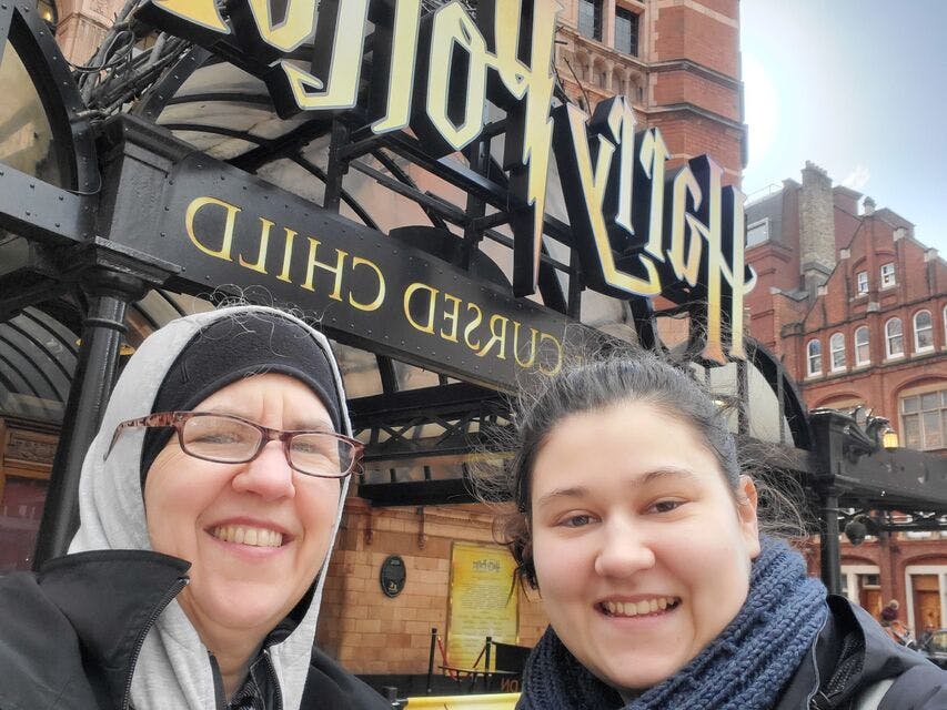 '해리포터와 저주받은 아이' 극장 입구 앞에서 웃고 있는 두 사람.