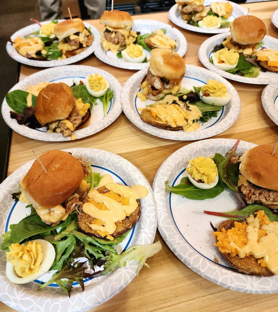 양상추, 데블드 에그, 기타 장식된 토핑이 있는 슬라이더가 나무 테이블에 놓여 있습니다.