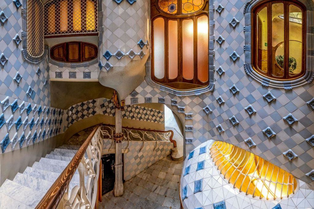 파란색과 흰색 모자이크 타일, 곡선형 계단, 따뜻한 색조의 스테인드글라스 창문이 있는 정교하게 디자인된 인테리어.