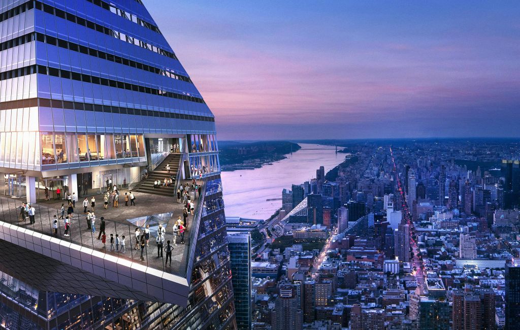 해질 무렵 강과 도시 풍경이 내려다보이는 현대적인 고층 건물의 높은 테라스에 서서 걷고 있는 사람들.