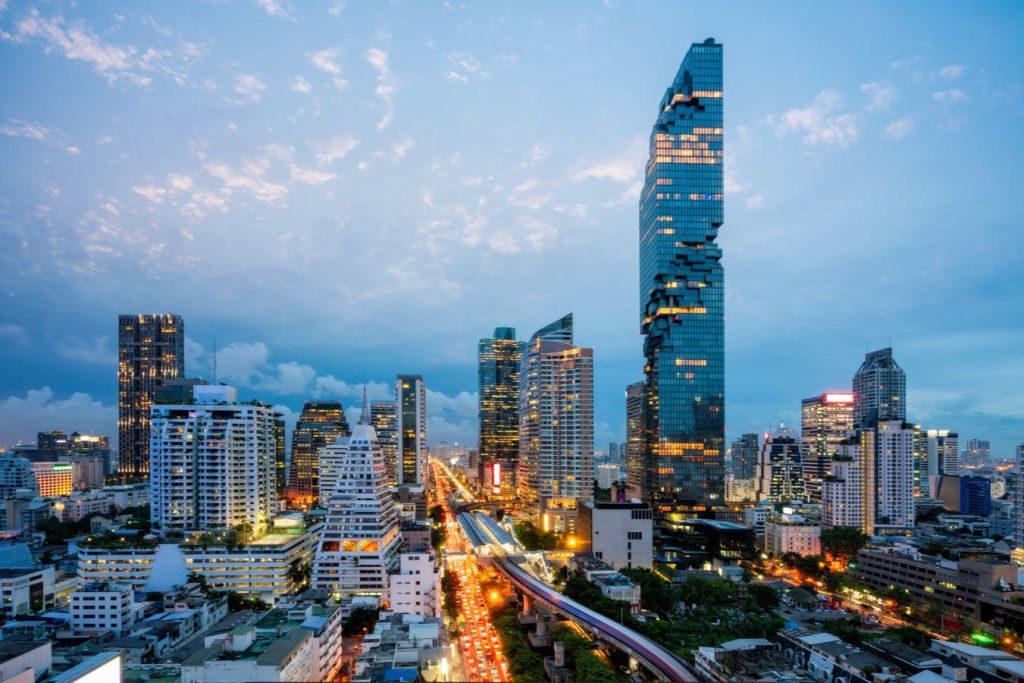 독특한 픽셀화 마천루와 분주한 조명을 자랑하는 해질녘의 도시 스카이라인.