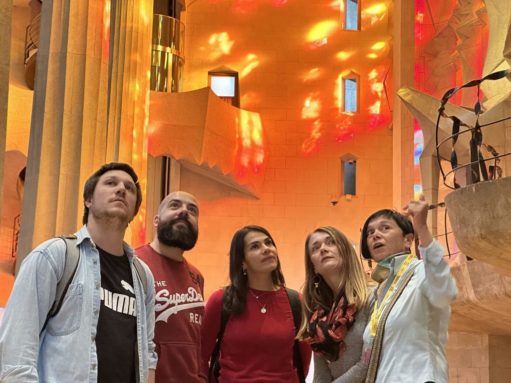 정교한 건축물과 스테인드글라스 창문이 있는 밝고 화려한 인테리어의 4인조 그룹입니다.