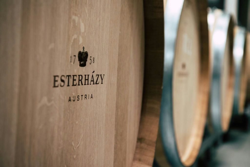 "Esterházy Austria" 와 "1758" 이 인쇄된 나무 통의 클로즈업. 다른 배럴의 세부 사항은 초점이 맞지 않습니다.