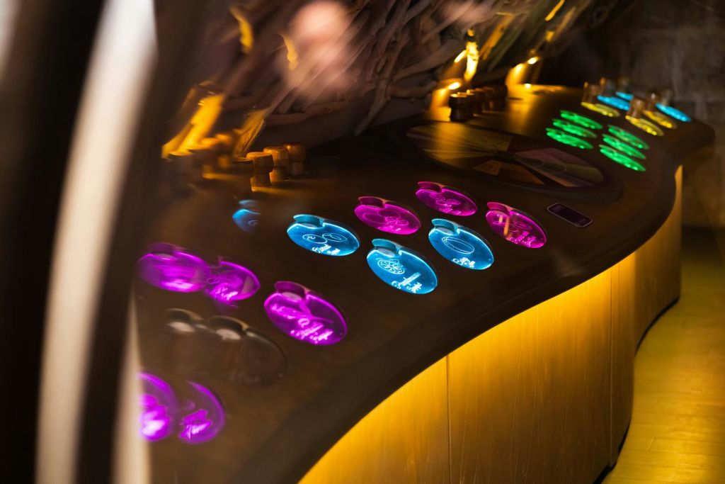어두운 조명에서 곡선 표면에 자주색과 파란색으로 빛나는 조명 원형 버튼의 다채로운 디스플레이.