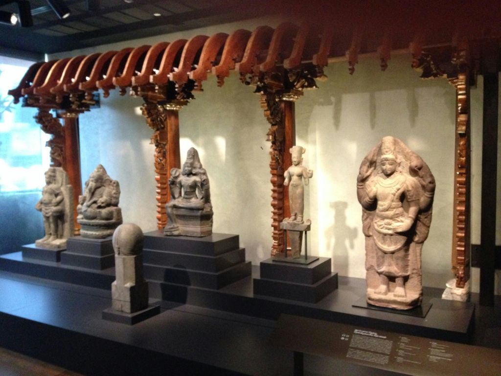 박물관 전시관에 전시된 화려한 목조 아치와 석조 조각품.