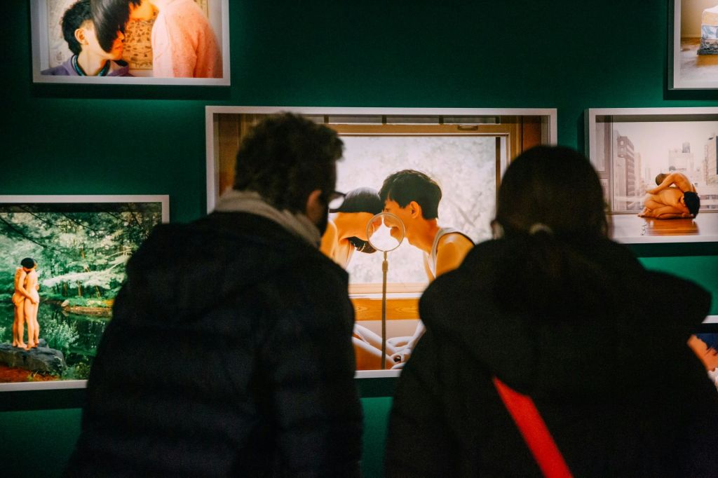 두 명의 게스트가 Fotografiska에서 Pixy Liao의 작품을 감상합니다.