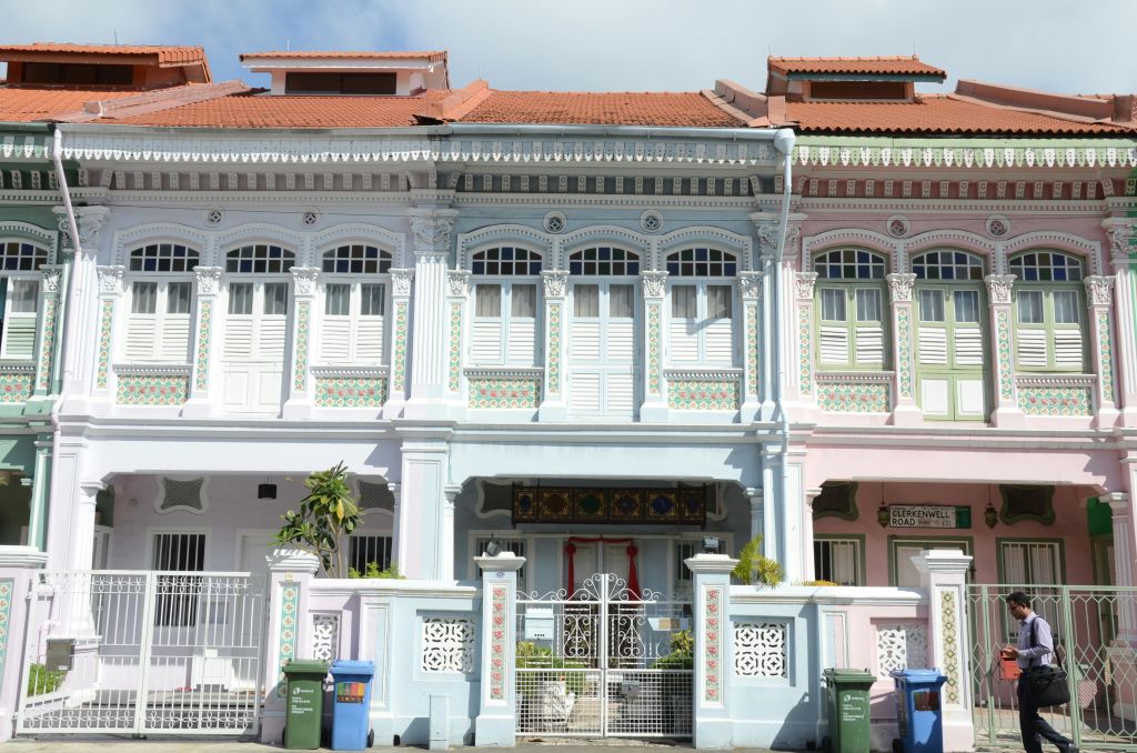 화이트 셔터, 화려한 장식, 작은 발코니 등 세부적인 건축 디자인이 돋보이는 파스텔 색상의 타운하우스가 줄지어 있습니다.