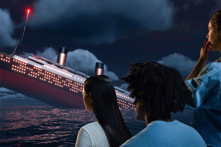 두 사람이 흐린 하늘 아래 밤바다에 가라앉은 크고 빛나는 배를 지켜보고 있습니다.