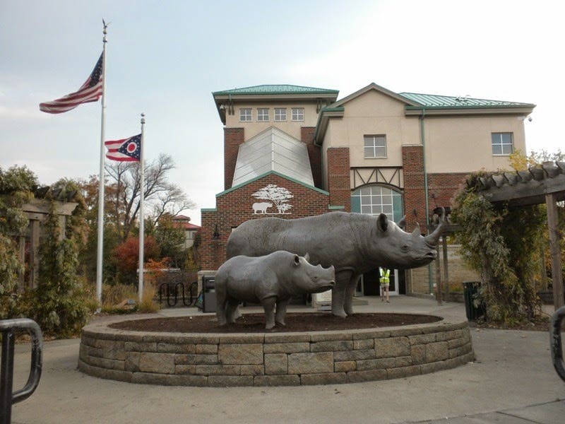 건물과 두 개의 깃발을 배경으로 석조 플랫폼에 두 개의 코뿔소 조각상.