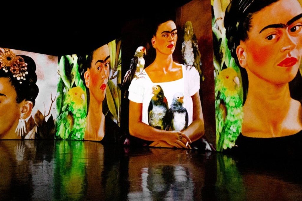 반짝이는 표면에 비친 새를 가진 여성의 초상화를 보여주는 밝고 다양한 패널의 작품.