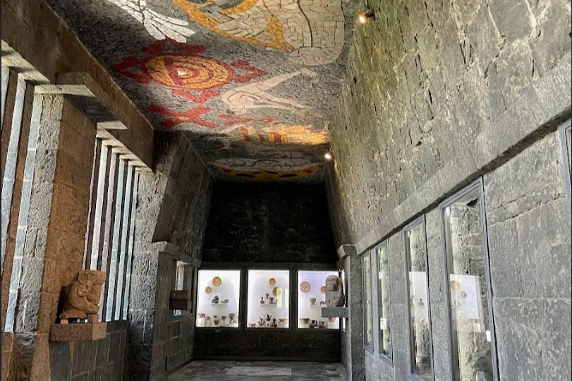 도자기 진열장, 기하학적 무늬가 있는 모자이크 천장, 희미한 조명이 있는 석실.