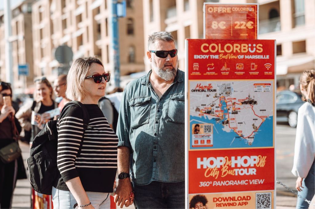 역사적인 건물로 둘러싸인 도시 광장에 'Colorbus Marseille' 이라는 이름의 2층 관광 버스가 있습니다.