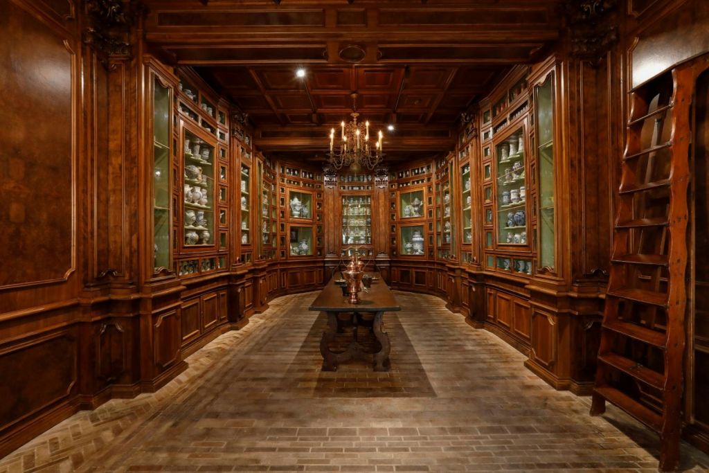 고급 중국, 중앙 테이블, 벽돌 바닥, 샹들리에가 있는 나무 수납장이 있는 고급스럽고 따뜻한 조명의 앤티크 룸입니다.