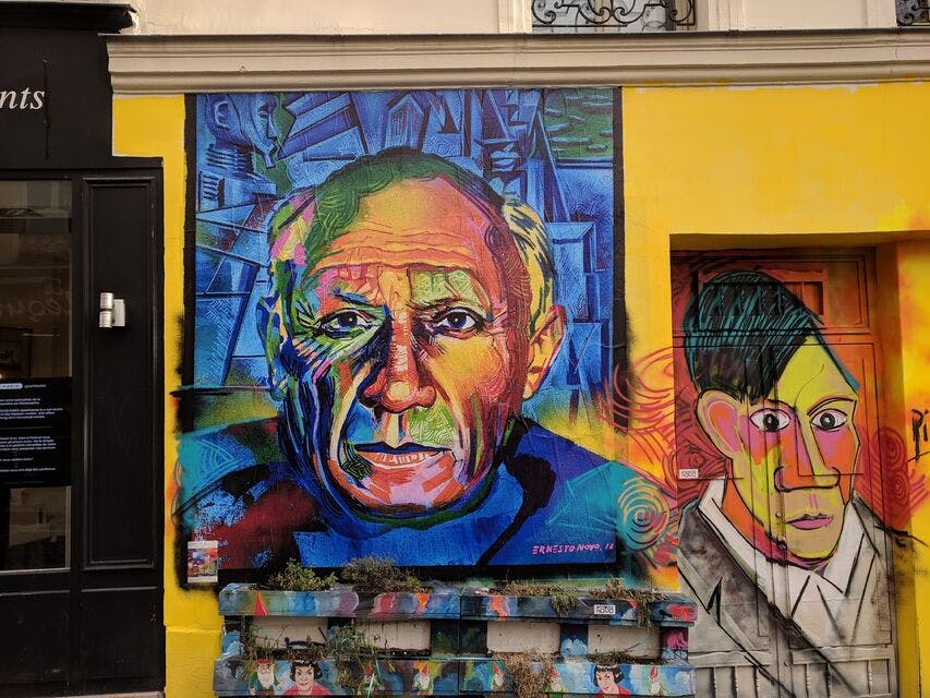 활기차고 추상적인 배경 요소와 오른쪽의 작은 창문이 있는 노란색 벽에 노인의 얼굴이 화려하게 그려져 있습니다.