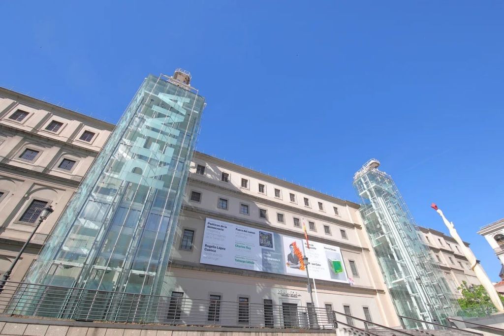 건물의 역사적인 외관과 연결된 현대적인 구조물인 레이나 소피아 미술관의 유리 엘리베이터.