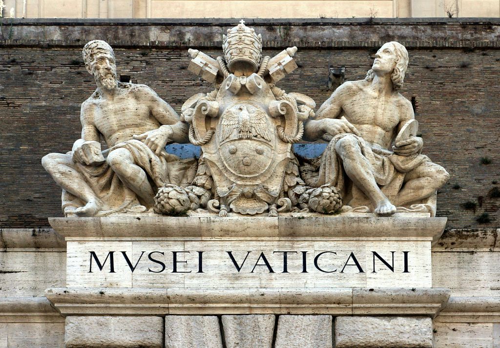 "MVSEI VATICANI" 라는 문구가 적힌 바티칸 문장 옆에는 앉은 두 개의 석상이 있습니다.