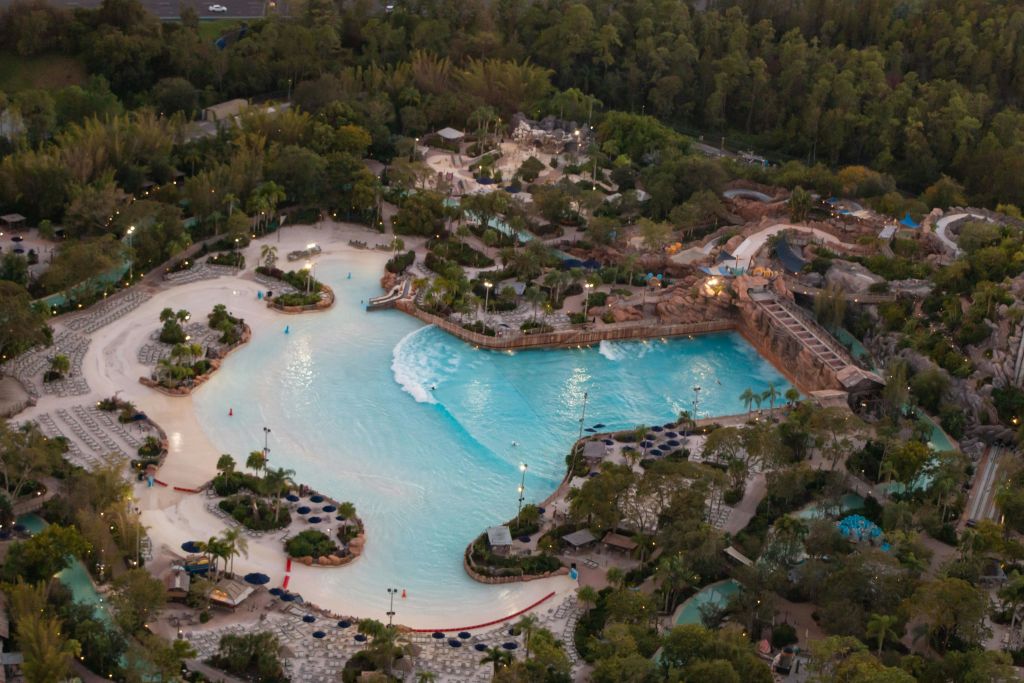 녹지, 산책로, 다양한 수상 관광지로 둘러싸인 파도풀이 있는 대형 워터파크의 공중 전망.